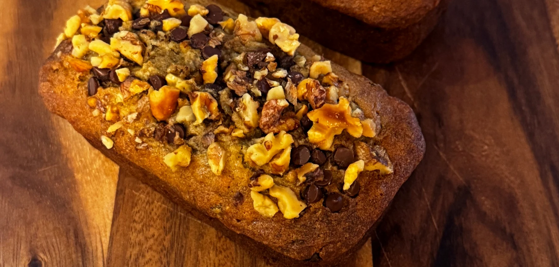 Banana Boss walnut and chocolate chip banana bread loaves on a wooden board